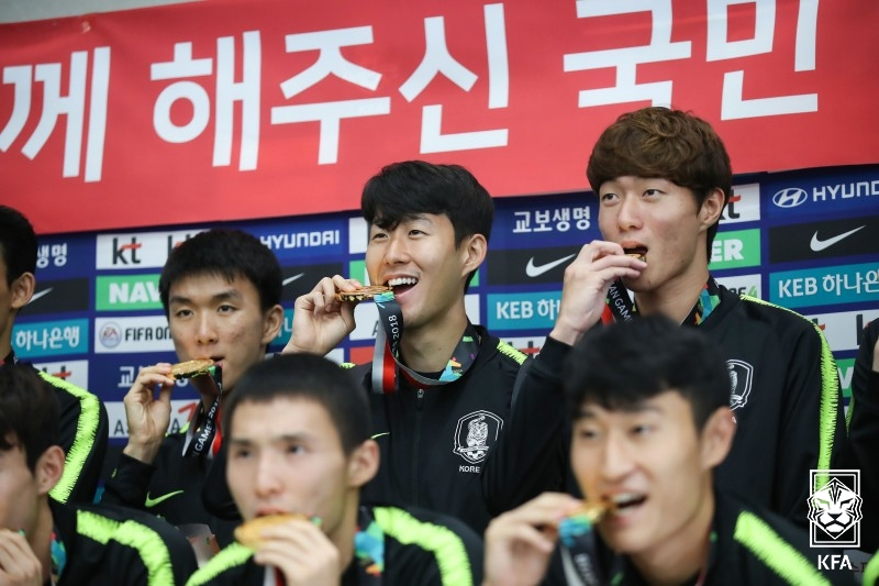 孙兴慜(中)因2018年雅加达-巨港亚运会男子足球金牌而获得兵役特例。 =图为，韩国足球协会提供。