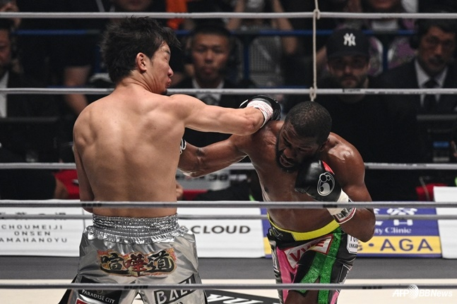 Mikuru Asakura is hitting the right-handed counter during a game against Floyd Mayweather (right) in 2022. /AFPBBNews=News1