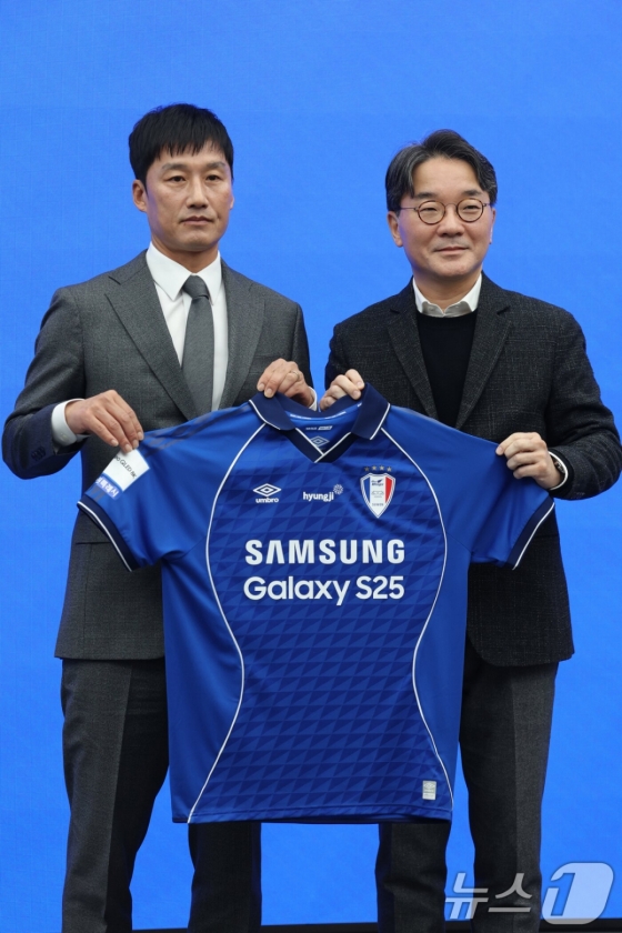 Coach Lee Jung-hyo (left) poses with a Suwon uniform. /Photo = News 1