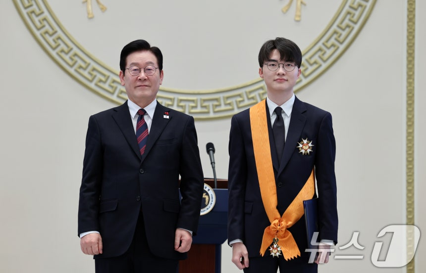 Professional gamer Faker (Lee Sang-hyuk, right) is taking a commemorative photo after receiving a medal of merit from President Lee Jae-myung at the 2026 New Year's greeting ceremony held at the Blue House Guest House on the 2nd. /Photo=Courtesy of News 1