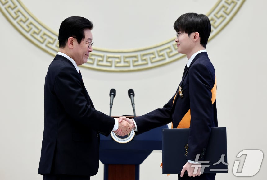Professional gamer Faker (Lee Sang-hyuk, right) shakes hands with President Lee Jae-myung after receiving a medal of merit for sports at the 2026 New Year's greeting ceremony held at the Blue House Guest House on the 2nd. /Photo=Courtesy of News 1