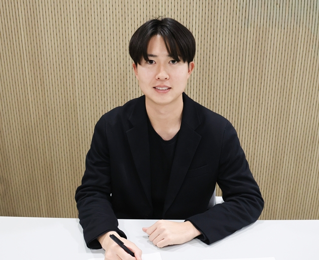 正在合同上签名的京山正也。 =照片:乐天巨人队。