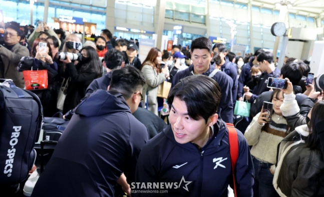 图为金惠成（前）正在向来到机场的粉丝们致意。 =照片=高级记者姜英祖。