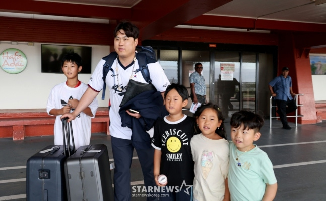 Ryu Hyun-jin (thứ hai từ trái sang) đang chụp ảnh kỷ niệm với người hâm mộ bóng chày trẻ tuổi sau khi đến sân bay Saipan. /Ảnh = Phóng viên cao cấp Kang Young Jo