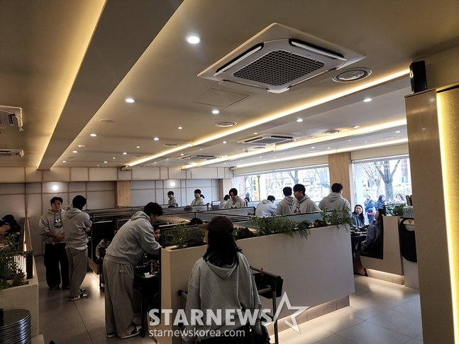 图为，三星选手们正在按桌子给烤肉。 =照片=韩联社记者朴秀珍。