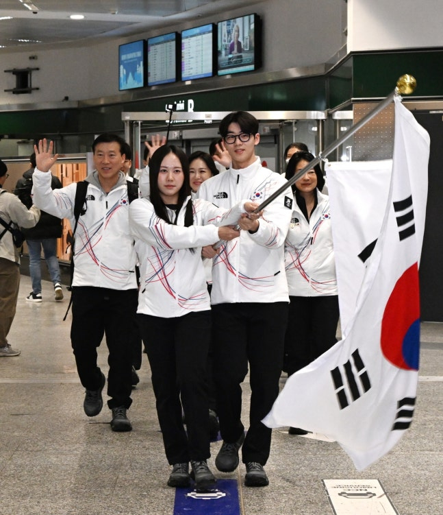 出战2026米兰、科尔蒂纳丹佩佐冬奥会的韩国代表团于31日带着太极旗抵达决战地意大利。 图为抵达米兰的朴智友（左）和李俊书举着太极旗走出国门。 =照片=大韩体育会提供。