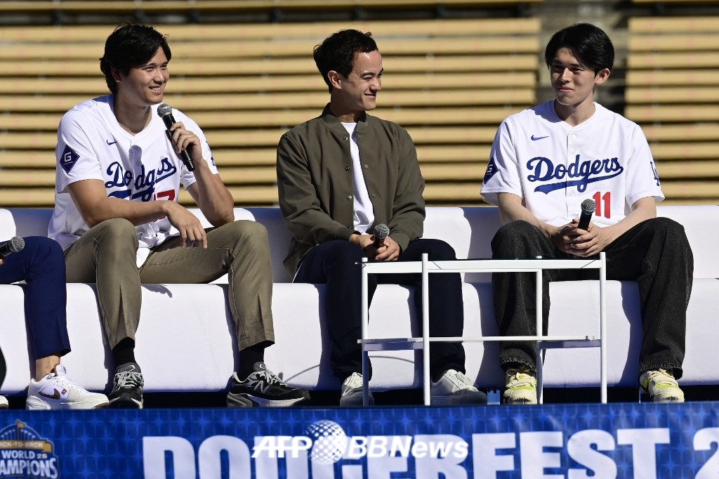 LA Dodgers Shohei Ohtani (left) speaks with Rocky Sasaki (right) at a fan festival held at Dodger Stadium in Los Angeles, California on January 31 (local time). Ohtani's interpreter, Will Ayerton, is helping them interpret. /AFPBBNews=News1