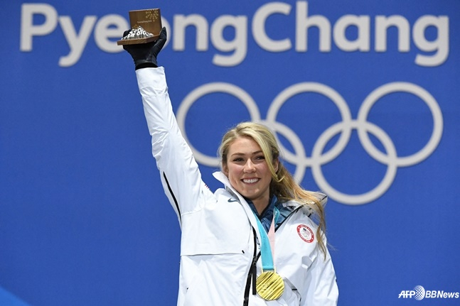 Michaela Ciprin đang giơ tay phải lên cao với huy chương vàng trên cổ trong Thế vận hội mùa đông Pyeongchang. /AFPBBNews = Tin tức 1