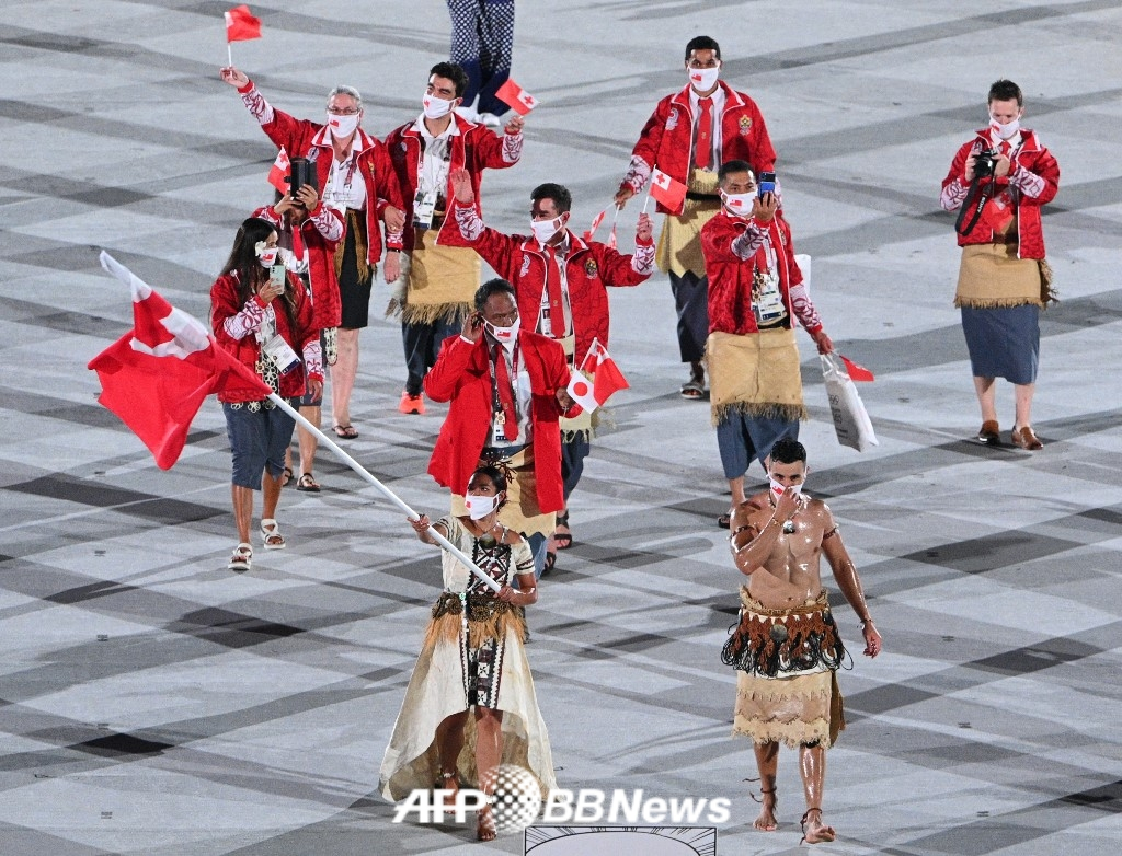  Человек-мышечник "Тонга" Пита Таупатопуа (справа внизу) был знаменосцем во время церемонии открытия Олимпийских игр 2020 года в Токио. /AFPBBNews =Новости 1