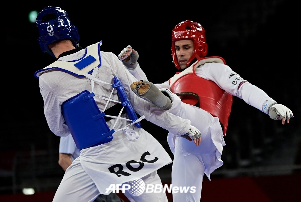  "Тонга Мускулистый Человек" Пита Таупатопуа (справа) выступает в качестве тхэквондо на Олимпийских играх 2020 года в Токио и участвует в соревнованиях. /AFPBBNews =Новости 1