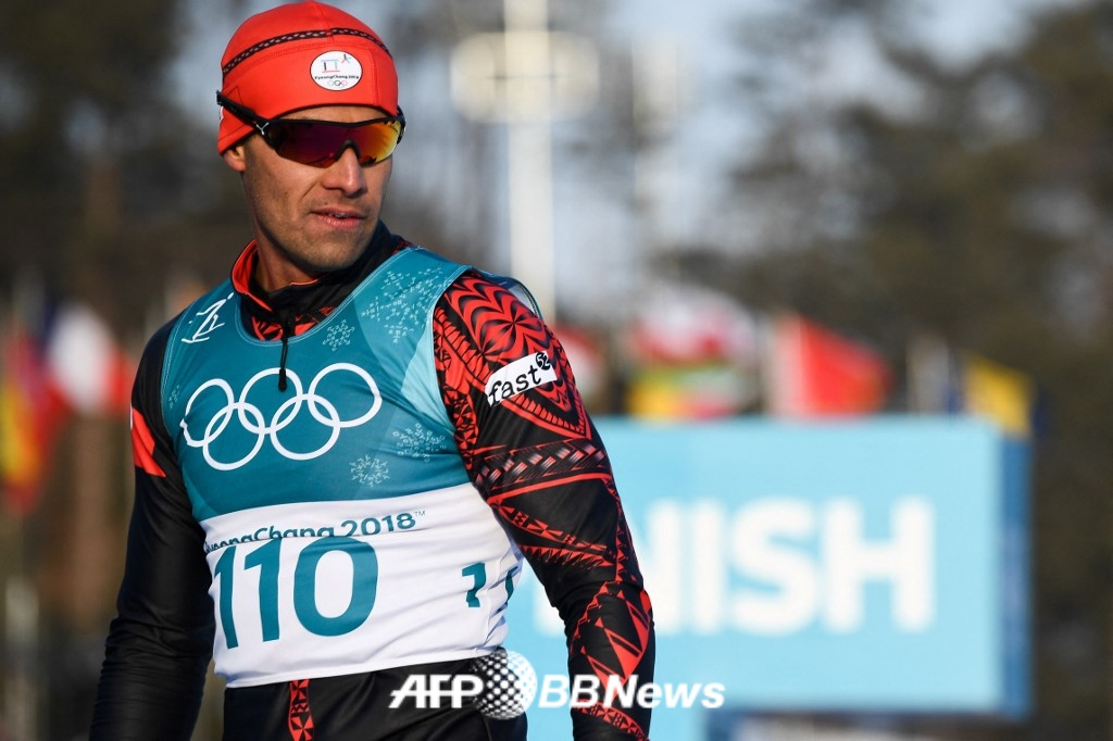  "Тонга Мускулистый Человек" Пита Таупатопуа (справа) выступает в качестве лыжницы и участвует в соревнованиях во время Олимпийских игр 2018 года в Пхенчхане. /AFPBBNews =Новости 1