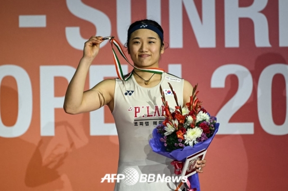 安世英在位于印度新德里的英迪拉甘地体育中心举行的世界羽毛球联盟(BWF)世界巡回赛超级750印度公开赛女子单打决赛中夺冠后,正摆出造型,供记者们拍照。 =法新社BBNews=新闻1。