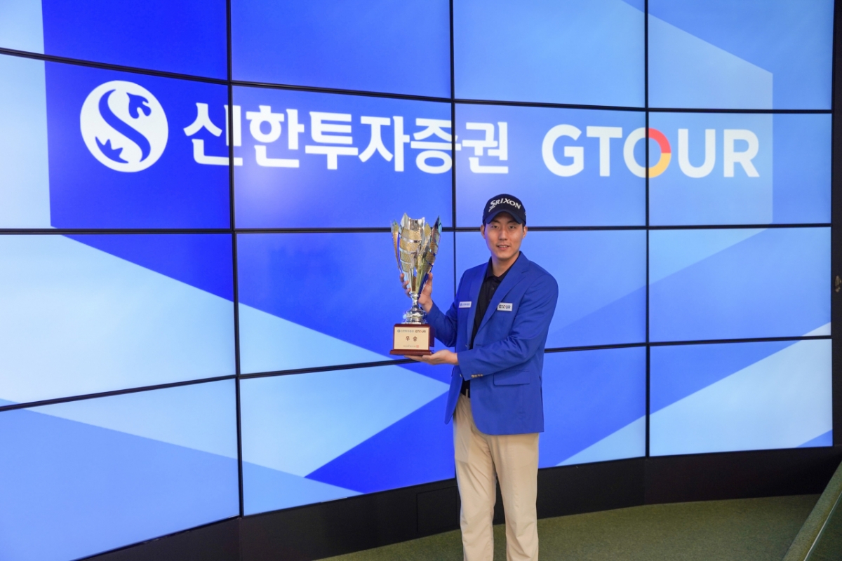 Jang Jungwoo is taking a commemorative photo with the trophy