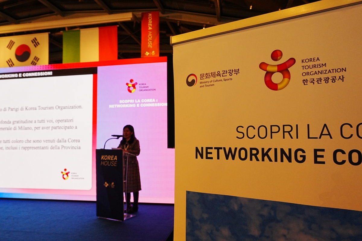 The Paris branch manager is giving a welcome speech at a business networking event