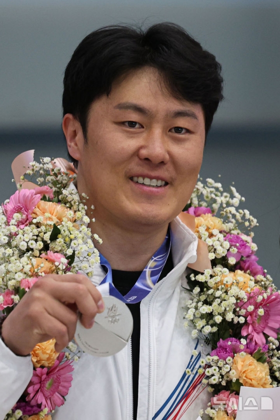 Kim Sang-gyeom, who won the silver medal in the men's parallel snowboarding competition at the 2026 Milan and Cortina D'Ampezzo Winter Olympics, returns home through Incheon International Airport's Passenger Terminal 1 on the 10th to receive a silver medal. /Photo = Newsis