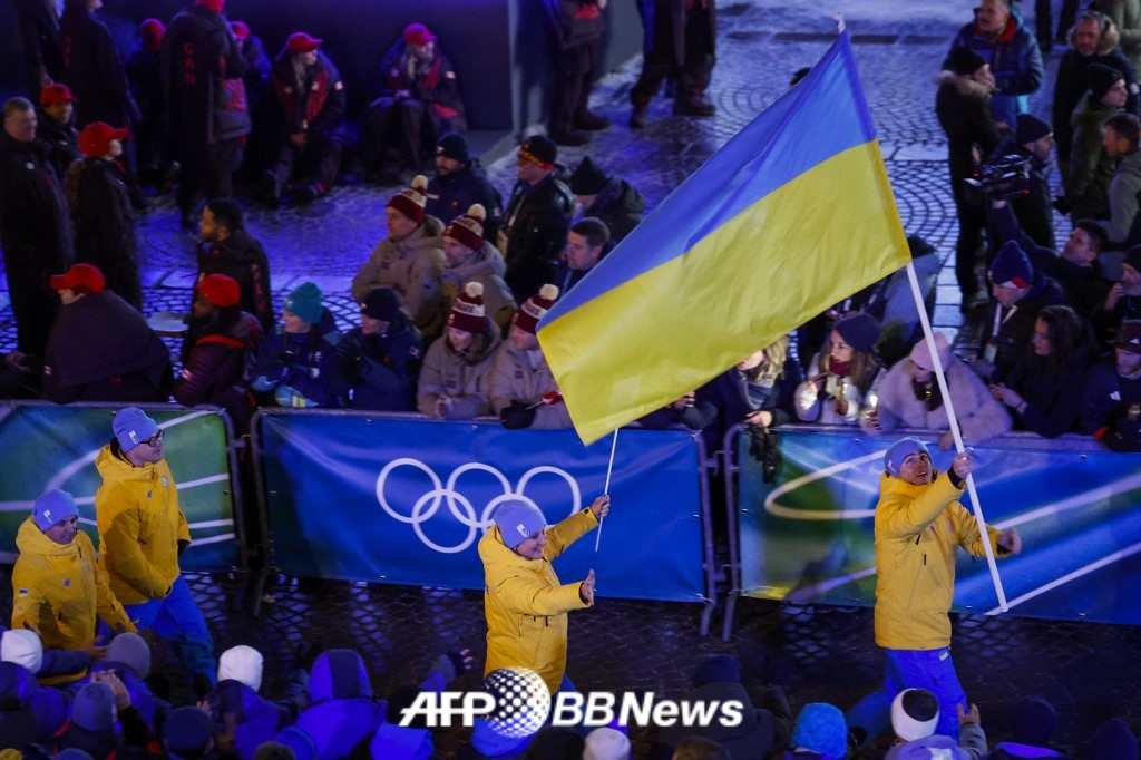 Vladislav Heraskevich (right), a member of the Ukrainian skeleton national team, is the Ukrainian flag bearer at the opening ceremony of the 2026 Milan-Cortina D'Ampezzo Winter Olympics. /AFPBBNews=News1