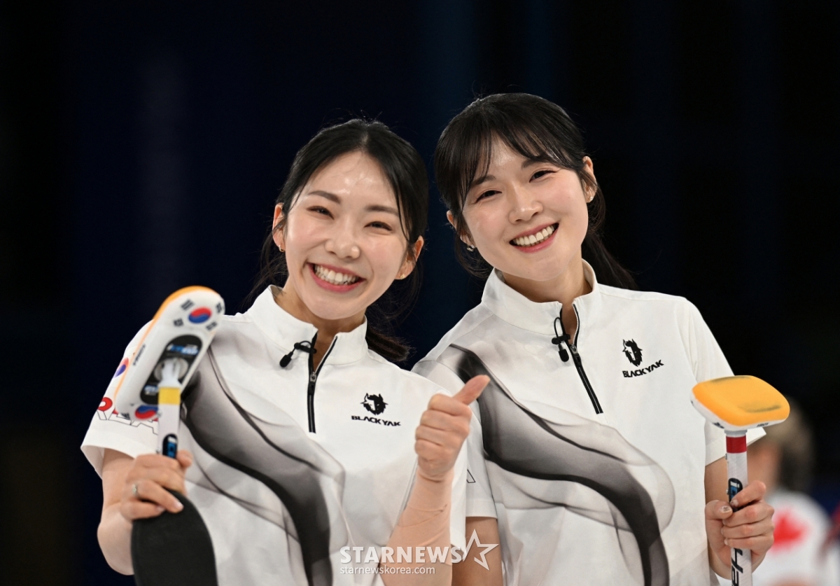 13日(当地时间)，韩国女子冰壶代表队京畿道厅的金秀智(左)和薛艺恩在意大利科尔蒂纳丹佩佐的科尔蒂纳冰壶奥林匹克体育场举行的2026米兰•科尔蒂纳冬奥会冰壶循环赛第3轮比赛中战胜英国，露出了灿烂的笑容。 =路透社/news 1。