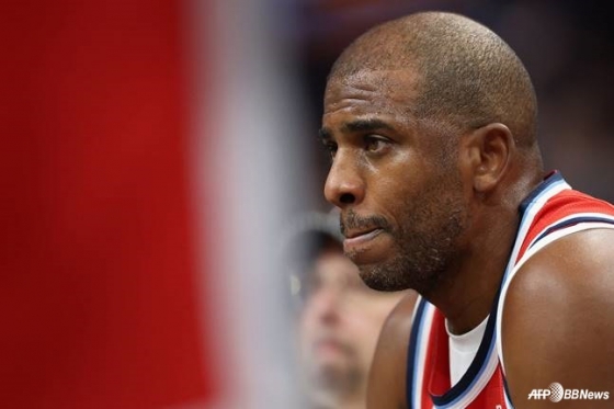 Chris Paul is sitting on the bench looking at the court. /AFPBBNews=News1