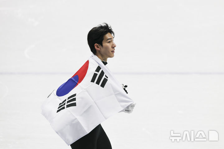 Hwang Dae-heon, a short track speed skater, is running around the stadium with a Korean flag after winning a silver medal in the men's 1,500m short track speed skating event at the 2026 Milan-Cortina D'Ampezzo Winter Olympics on the 14th (local time). /Photo = Newsis