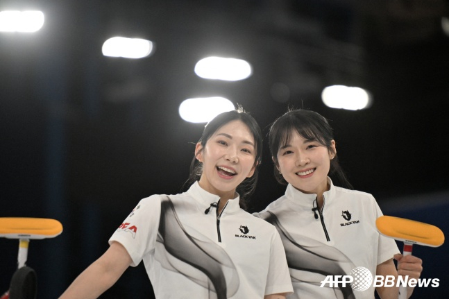 韓国女子カーリング代表チームの京畿道庁キム·スジ(左)とソル·イェウンが13日(現地時間)、イタリア·コルティナダンペッツォのコルティナカーリングオリンピックスタジアムで開かれた2026ミラノ·コルティナ冬季五輪カーリングラウンドロビン第3戦で英国を破って明るく笑っている。 /AFPBBNews=ニュース1