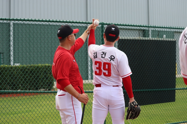 Kim Gun-woo (right) is being advised by coach Kyung Heon-ho during bullpen pitching. /Photo = Courtesy of SSG Landers