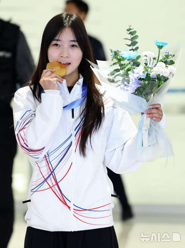 チェ·ガオンが入国場を出た後、金メダルを噛みながらポーズを取っている。 /写真=ニューシス
