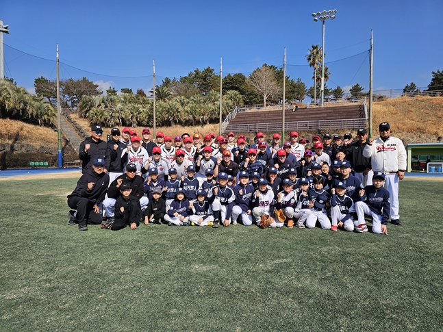 西帰浦リトル野球団を招待した蔚山ウェールズの選手たちが記念撮影をしている。 /写真=蔚山ウェールズ