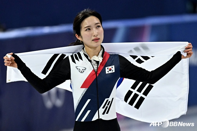 10月16日,2026米兰·科尔蒂纳丹佩佐冬奥会短道速滑女子1000米决赛在意大利米兰冰上竞技场举行,图为金吉利在决赛中以第三名的成绩通过后正举着太极旗绕着冰场向观众致意。 =法新社BBNews=新闻1。