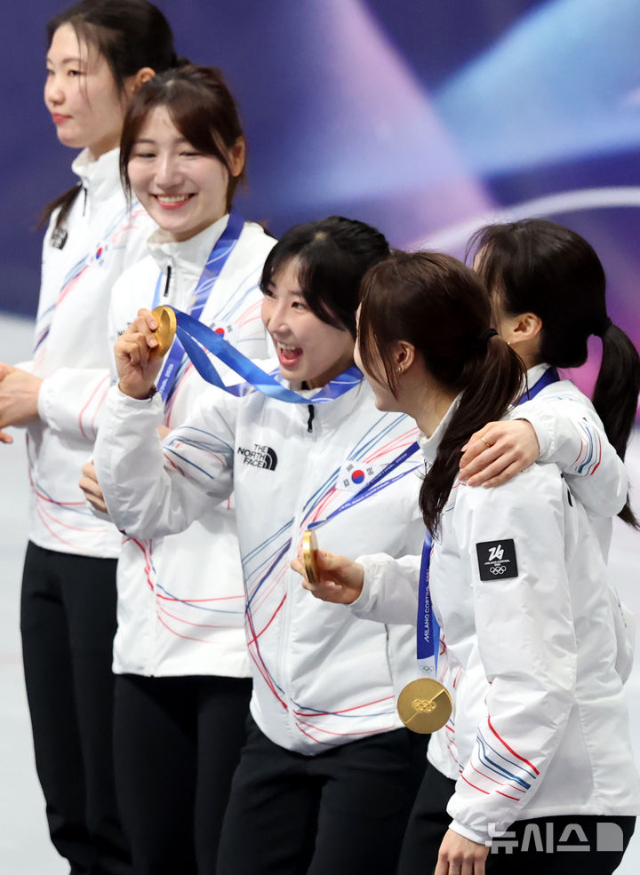 18日(当地时间)，在意大利米兰冰上滑冰竞技场举行的2026米兰•科尔蒂纳丹佩佐冬奥会短道速滑女子3000米接力颁奖典礼上，韩国女子代表队正带着金牌庆祝。 =照片=newsis。
