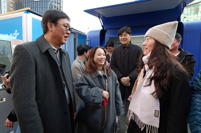 韩国文化体育观光部部长崔辉映(左)15日来到首尔中区明洞,会见中国春节长假期间访问韩国的中国游客。 =文体部。