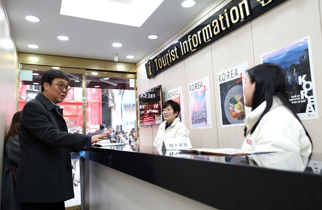 15日,崔辉映(左)部长来到明洞,正在听取旅游咨询处职员的意见。 =文体部。