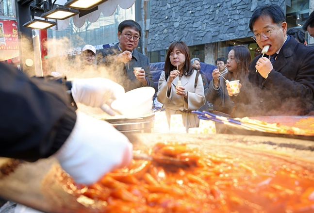 图为文化体育观光部部长崔辉映(左)正在明洞检查街头小吃。 =文体部。