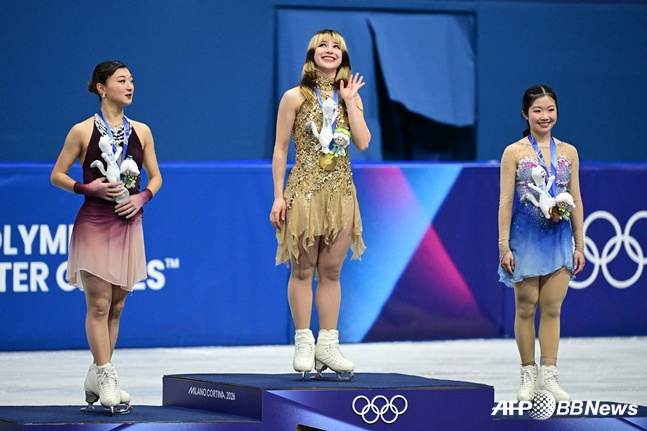 图为阿丽莎·刘(中)在2026米兰·科尔蒂纳丹佩佐冬奥会花样滑冰女单比赛中夺冠，与日本选手一起登上领奖台。 =法新社BBNews=新闻1。