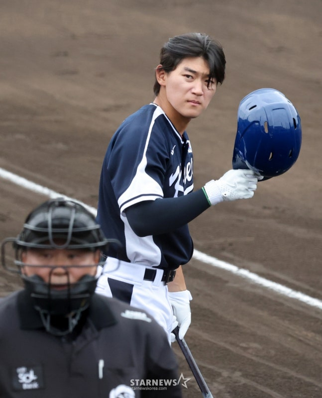 WBC代表队20日在日本冲绳Onnason Akama球场与三星狮子队进行了练习赛。  图为代表队金道英（音）在放飞秋天后正在改戴头盔。 =照片=金镇京。