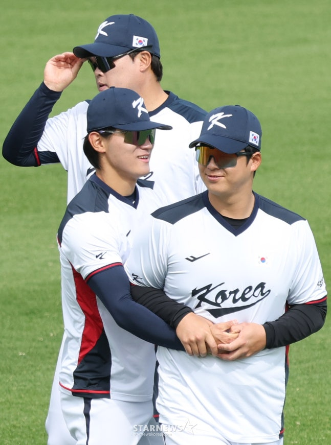 WBC代表队19日在日本冲绳Onnason Akama球场与三星狮子队进行了练习赛。  图为金道英（音）正热情地与卢时焕（音）打招呼进行训练。 =照片=金镇京。