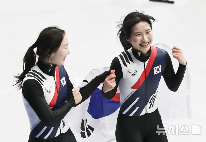 当地时间18日，在意大利米兰冰上滑冰馆举行的2026米兰冬奥会女子短道速滑3000米接力决赛中，短道速滑选手崔敏静和金吉利在比赛中获得金牌后分享着喜悦。 =照片=newsis。