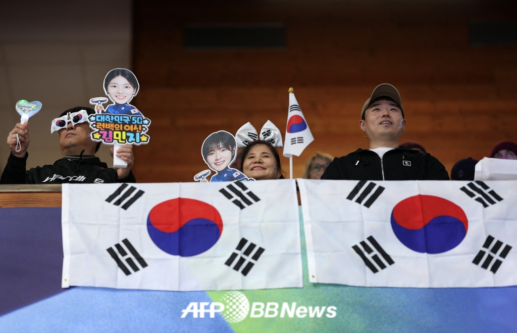 为韩国女子冰壶代表队加油的粉丝们。 悬挂着印有正确太极图案的太极旗助威。 =法新社BBNews=新闻1。