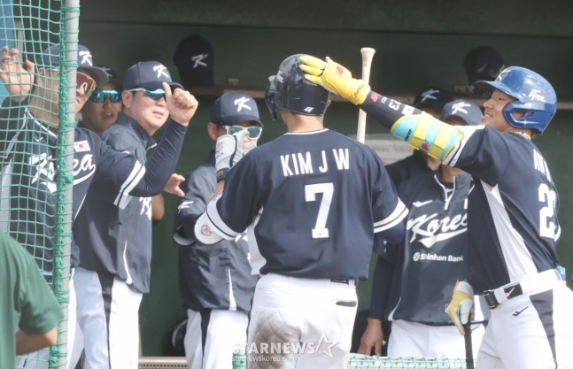 WBC韩国棒球代表队21日在日本冲绳县八重江户球场与韩华鹰队进行了练习赛。  代表队金周元在第7回合初无人出局1、2垒有人的情况下，面对韩华队的黄俊书击出反败为胜的3分本垒打后，受到了柳智贤教练的欢迎。 =照片=金镇京。