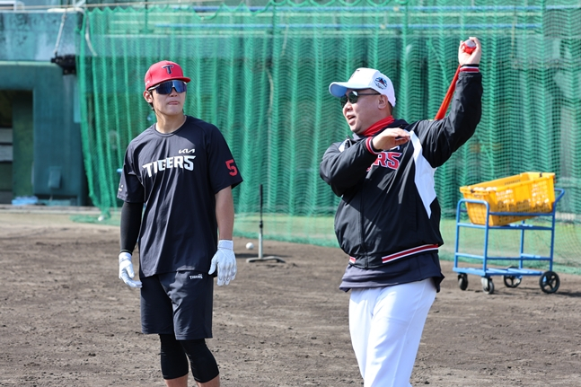 图为，主教练李范浩（右）正在指导金道英（左）击球。 =照片:起亚老虎队