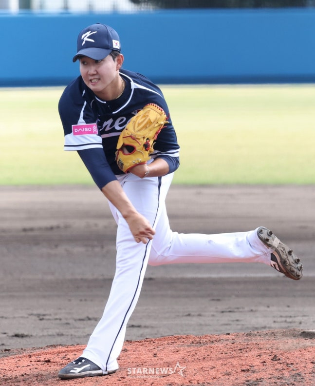 WBC韩国棒球代表队21日在日本冲绳县八重江户球场与韩华鹰队进行了练习赛。  代表队的柳永灿正在奋力拼搏。 =照片=金镇京。