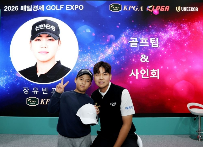 Jang Yoo-bin (right) is taking a commemorative photo with a children's fan at the "2026 Mail Business Golf Expo" on the 21st. /Photo = Courtesy of KPGA
