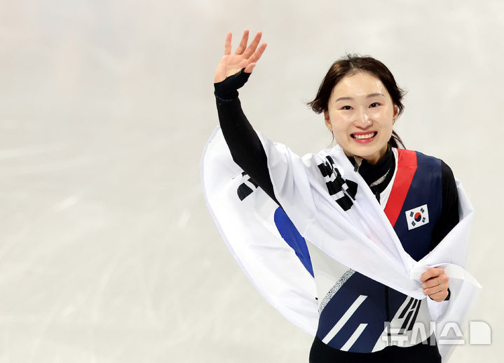 图为崔敏静（音）在获得女子1500米银牌后眼眶泛红，正围着太极旗与观众们打招呼。 =照片=newsis。