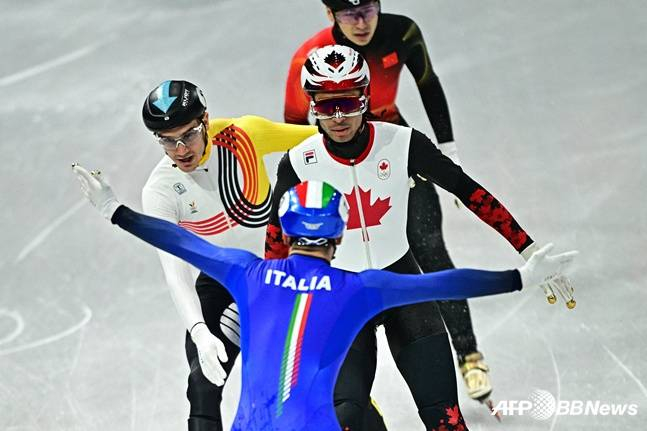 图为，本月10日在2026米兰和科尔蒂纳丹佩佐冬奥会短道速滑混合接力决赛中，正在向后转身冲过终点线的皮耶特罗-西格尔（前）和看着他的竞争国选手们。 =法新社BBNews=新闻1。