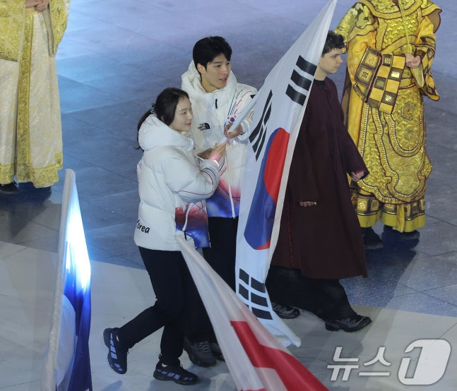 10月22日（当地时间），在意大利维罗纳奥林匹克竞技场举行的2026米兰·科尔蒂纳丹佩佐冬奥会闭幕式上，韩国代表团旗手崔敏静（音，左）和黄大宪正在入场。 =照片=news1（共同采访）