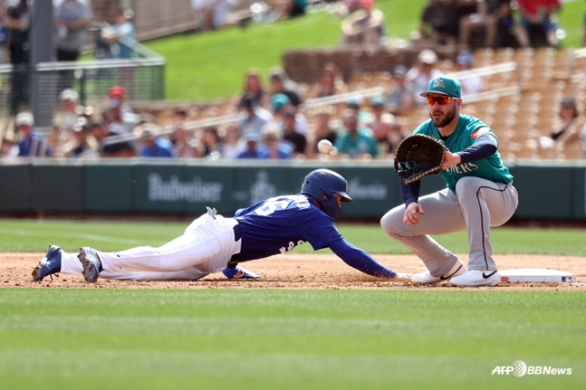 24日，在西雅图水手队的比赛中，金惠成（左）站在帕特里克·威兹德姆（右）守着的一垒回垒。 =法新社BBNews=新闻1。