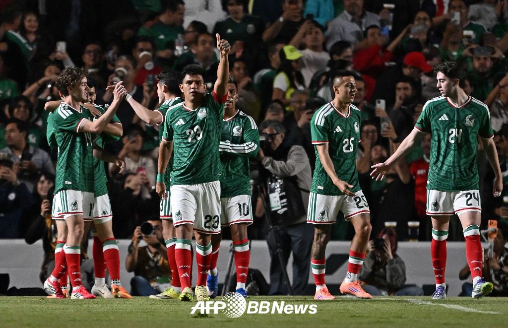 图为6月26日（韩国时间），墨西哥足球代表队在墨西哥凯雷塔罗举行的与冰岛的热身赛中进球后，正高兴得合不拢嘴。 =法新社BBNews=新闻1。