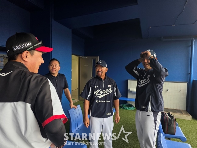 LG队主教练廉景烨（左）27日在日本冲绳县卡德纳球场鼓励了作为2026世界棒球经典赛（WBC）国家队教练加入训练教练的金龙一（中）和投手教练金光三（右）。 =照片=金东润。