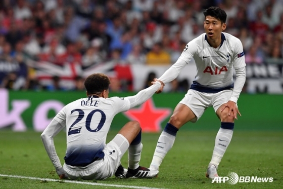 图为孙兴慜(右)正在扶起德里•阿里。 =法新社BBNews=新闻1。