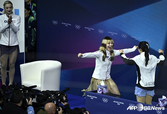 Alyssa Liu (center), who won the women's single figure skating title at the 2026 Milan/Cortina D'Ampezzo Winter Olympics, is delighted with bronze medal Nakai Ami (right). Amber Glenn (left) watches and applauds. /AFPBBNews=News1