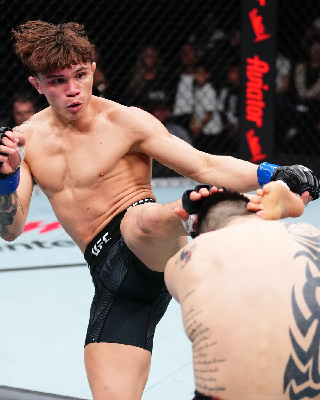 罗尼·卡瓦纳（左）向布兰登·莫雷诺射门。 =照片:UFC官方社交网络服务(SNS)